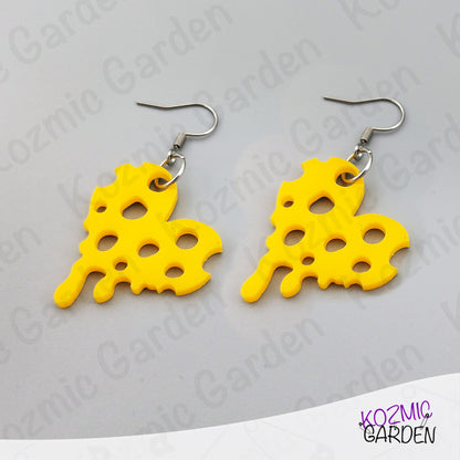 Yellow heart cheese-shaped earrings on a gray background with 'Kozmic Garden' branding.