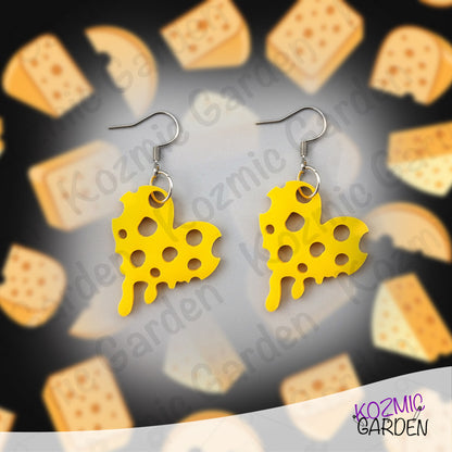 Yellow cheese-shaped earrings on a cracker-themed background with 'Kozmic Garden' branding.