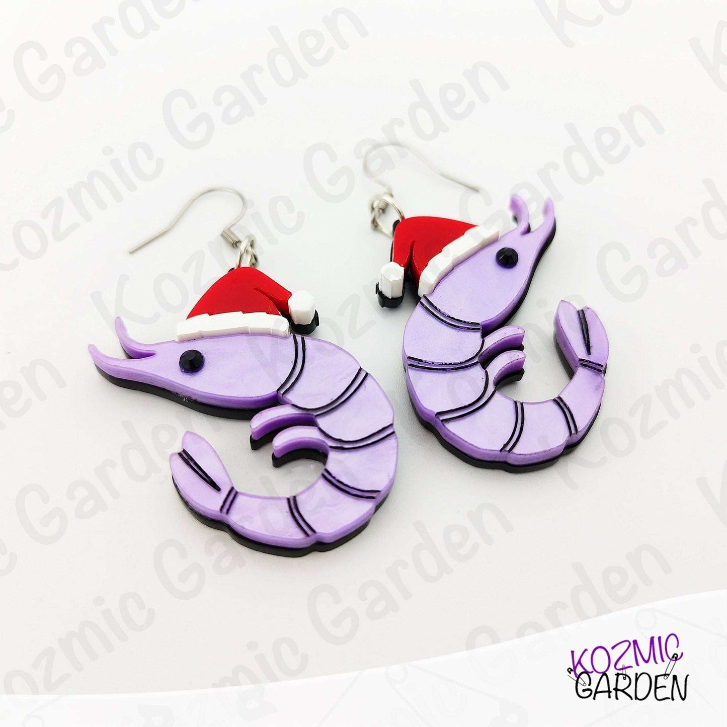 Purple shrimp earrings with Santa hats on a white background with 'Kozmic Garden' branding.