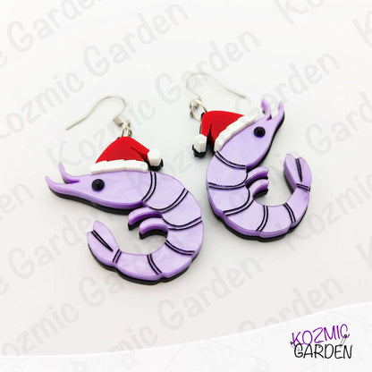 Purple shrimp earrings with Santa hats on a white background with 'Kozmic Garden' branding.