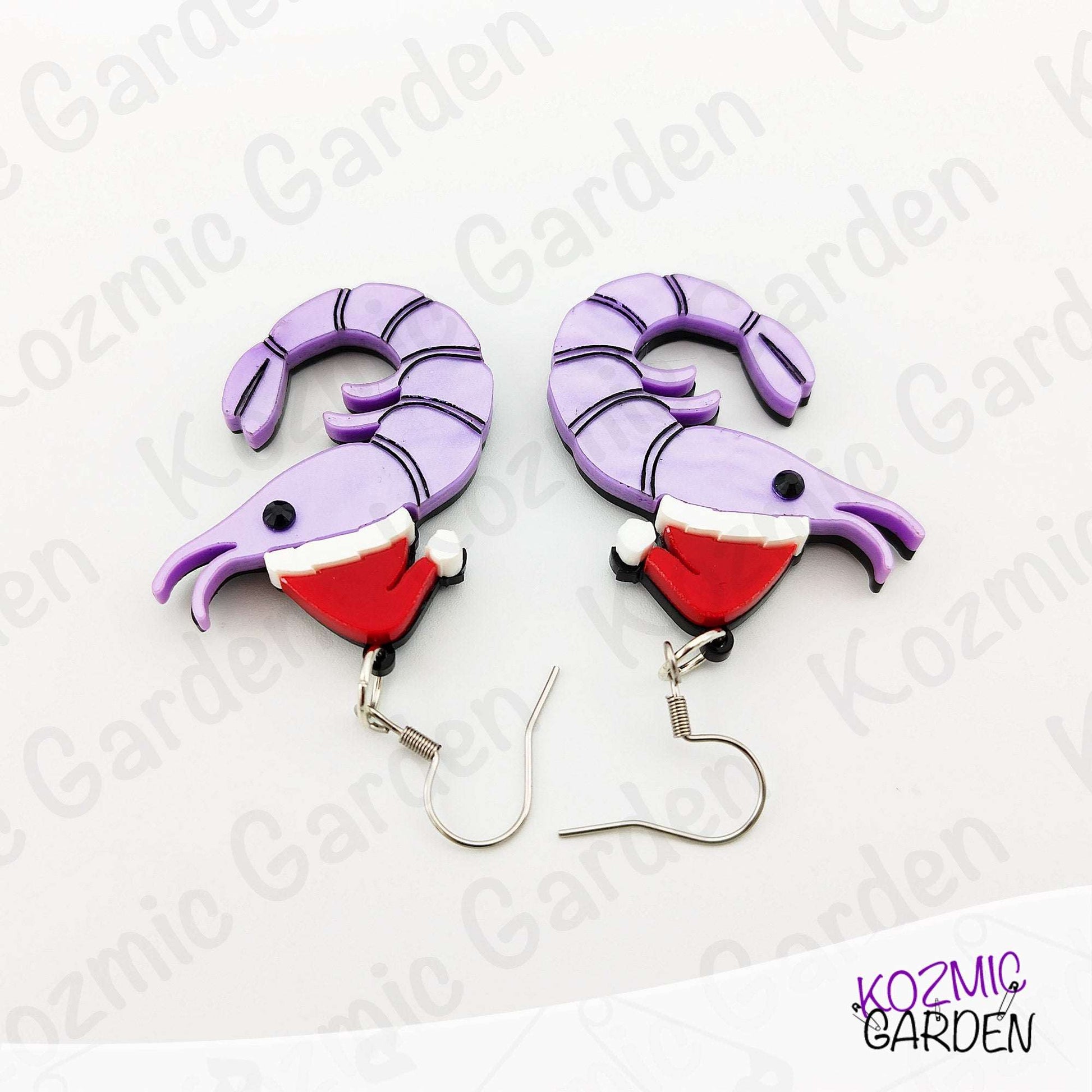 Pair of purple and red Christmas-themed earrings on a white background with 'Kozmic Garden' branding.