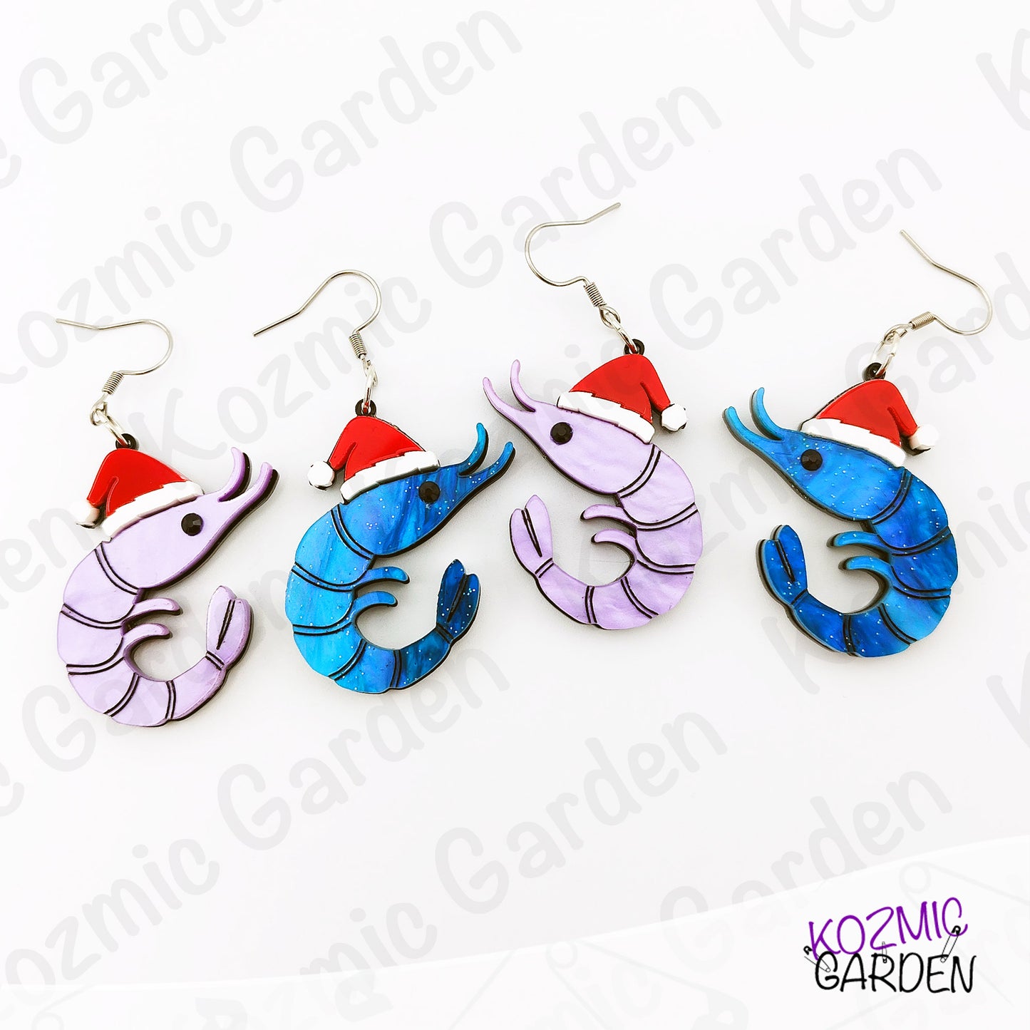 Colorful shrimp earrings with Santa hats on a white background, branded 'Kozmic Garden'.