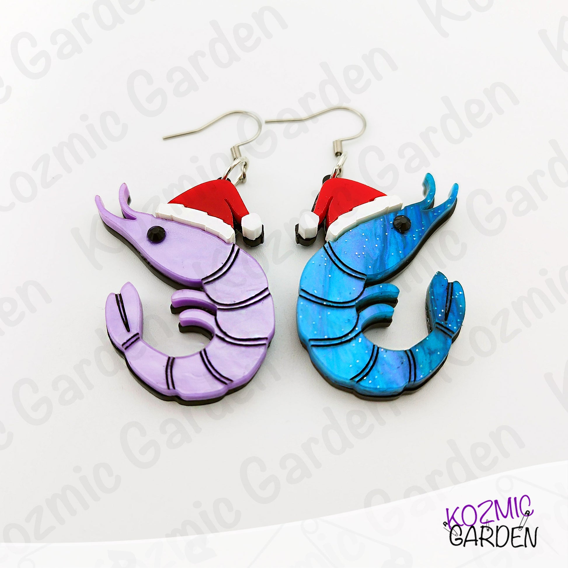 Shrimp-shaped earrings with red hats on a white background with 'Kozmic Garden' branding.