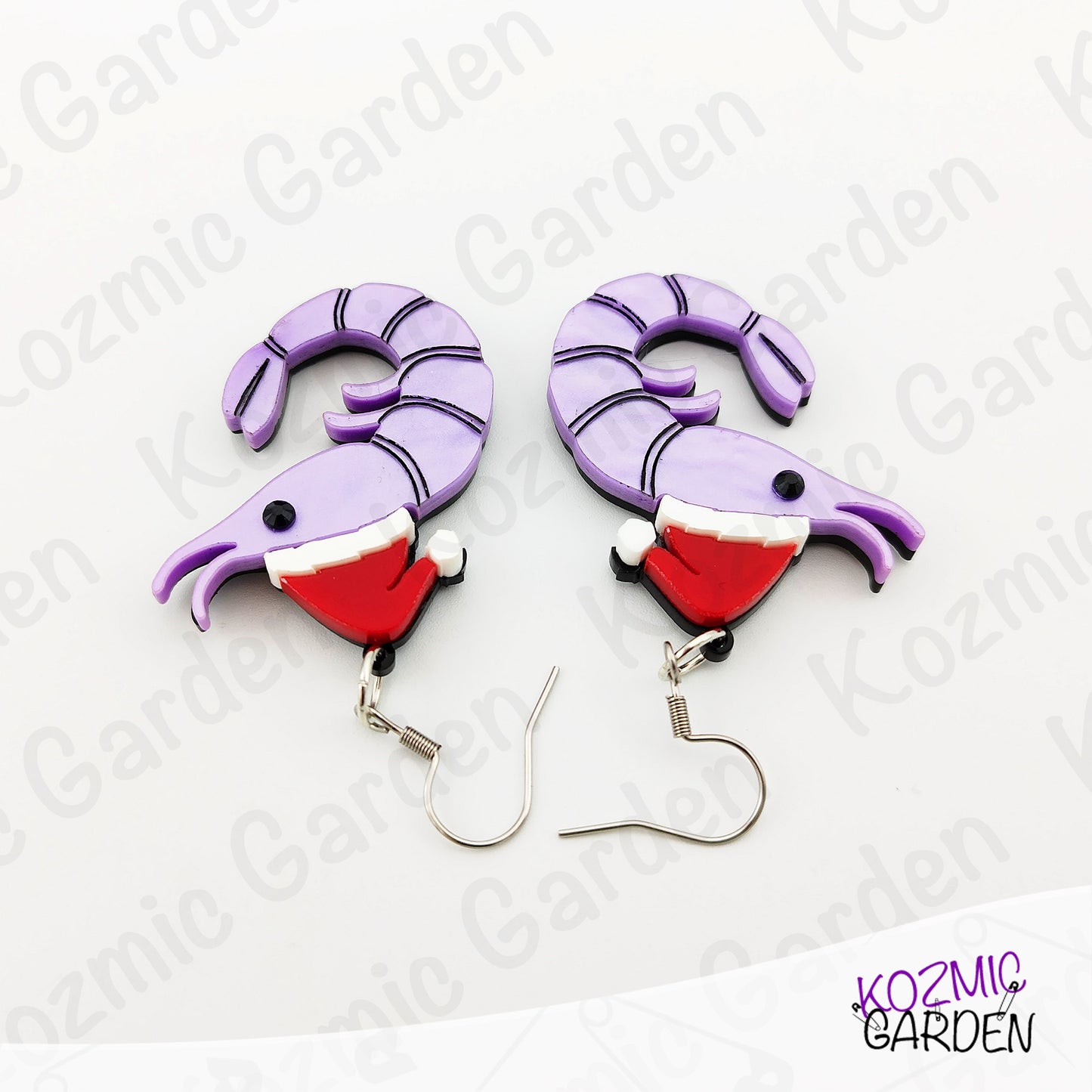 Pair of purple and red Christmas-themed earrings on a white background with 'Kozmic Garden' branding.