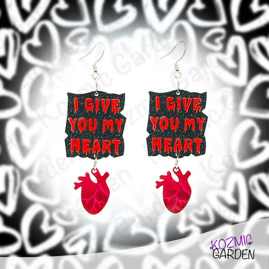 Earrings with 'I Give You My Heart' text and red heart design on a patterned background