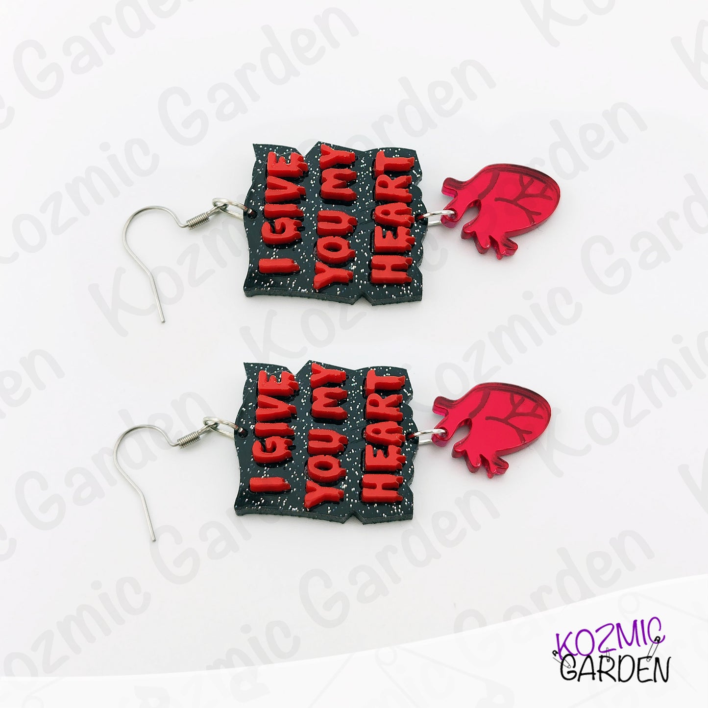 Pair of earrings with 'I Give You My Heart' text and red heart shapes on a white background.