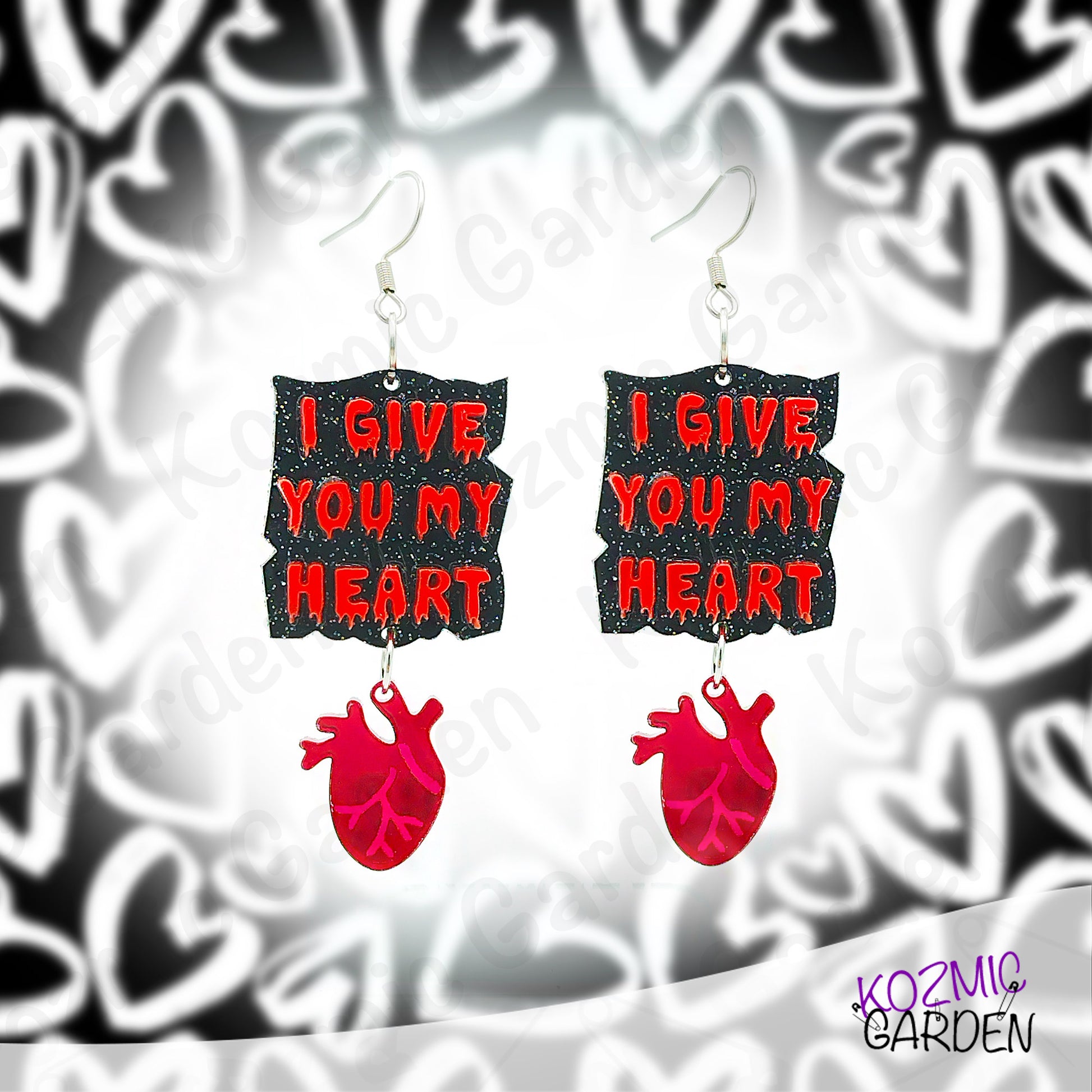 Earrings with 'I Give You My Heart' text and red heart design on a patterned background
