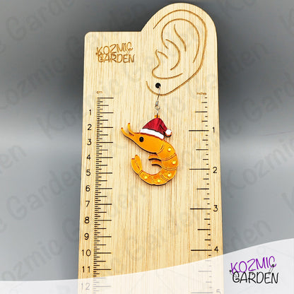 Wooden ruler with a shrimp ornament wearing a Santa hat on a gray background, branded 'Kozmic Garden'.