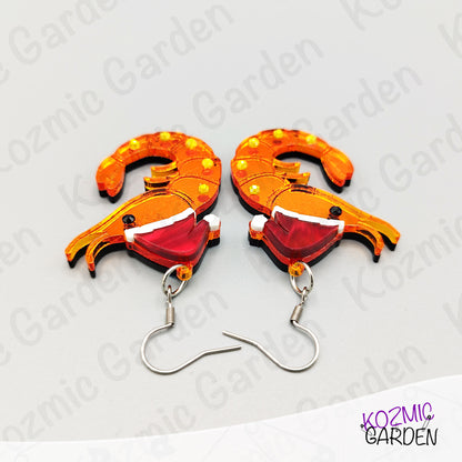 Shrimp-shaped earrings with orange and red design on a white background with 'Kozmic Garden' branding.