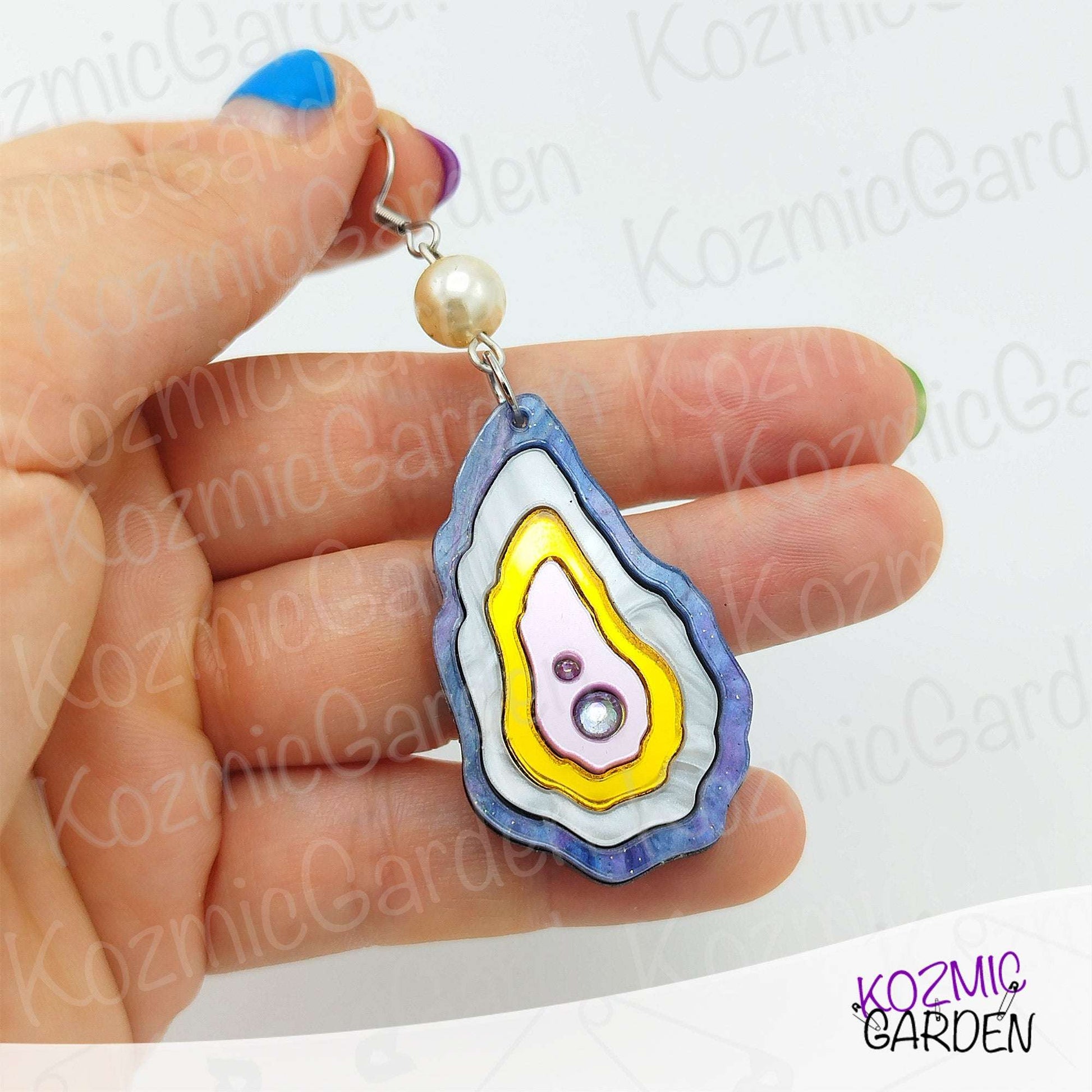 Close-up of oyster shell earrings with rhinestone pearl and white pearl stud