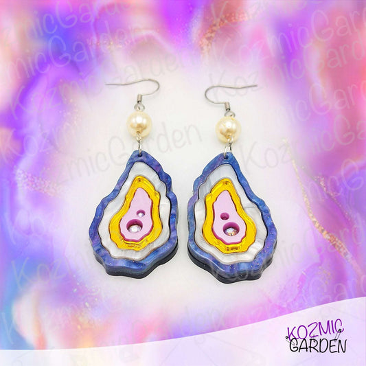 Layered seashell earrings in purplish, pearl, gold, and rose tones