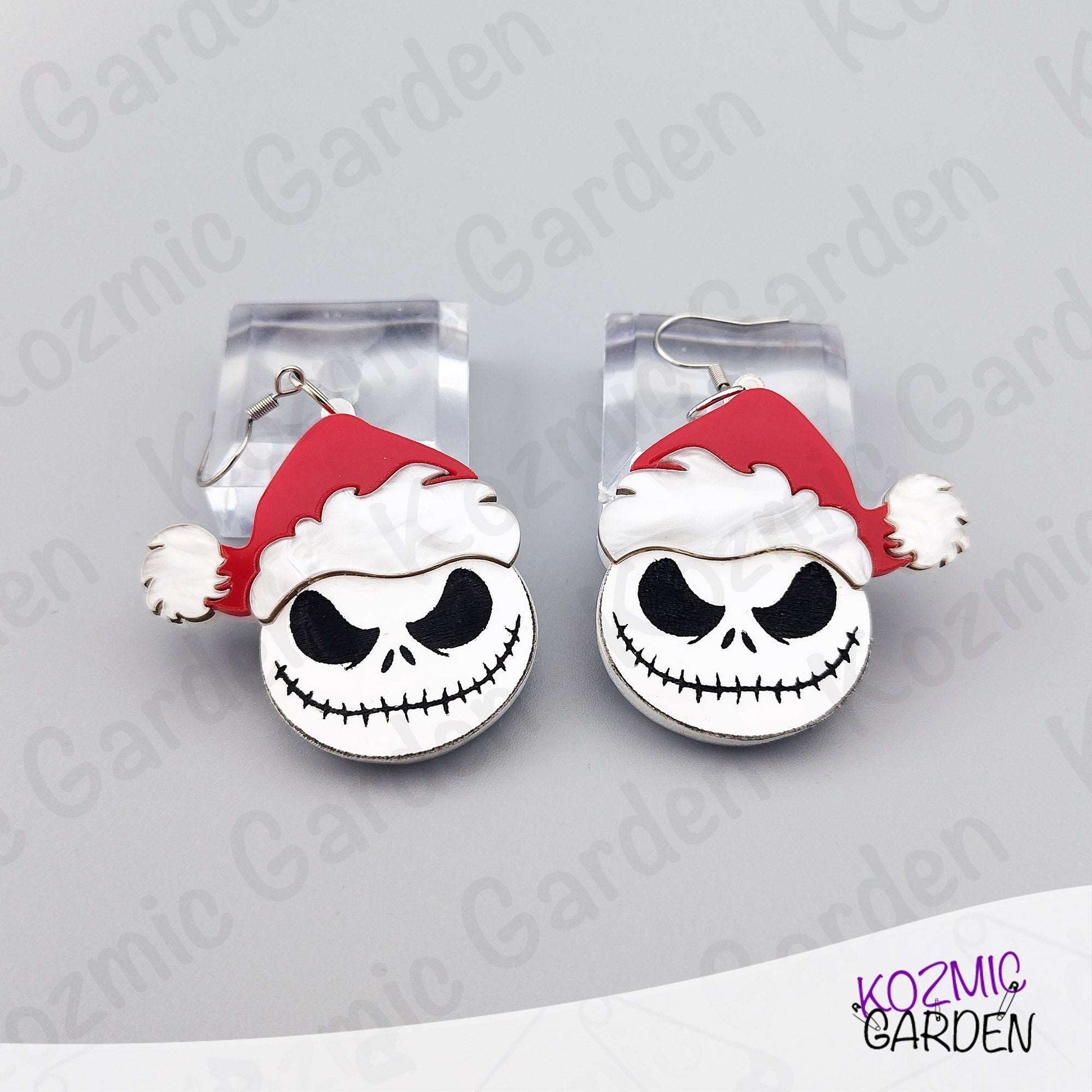 Close look at the black and white Jack Skellington face with a red Santa hat. Lightweight acrylic earrings with crisp engraved details and a glossy finish.