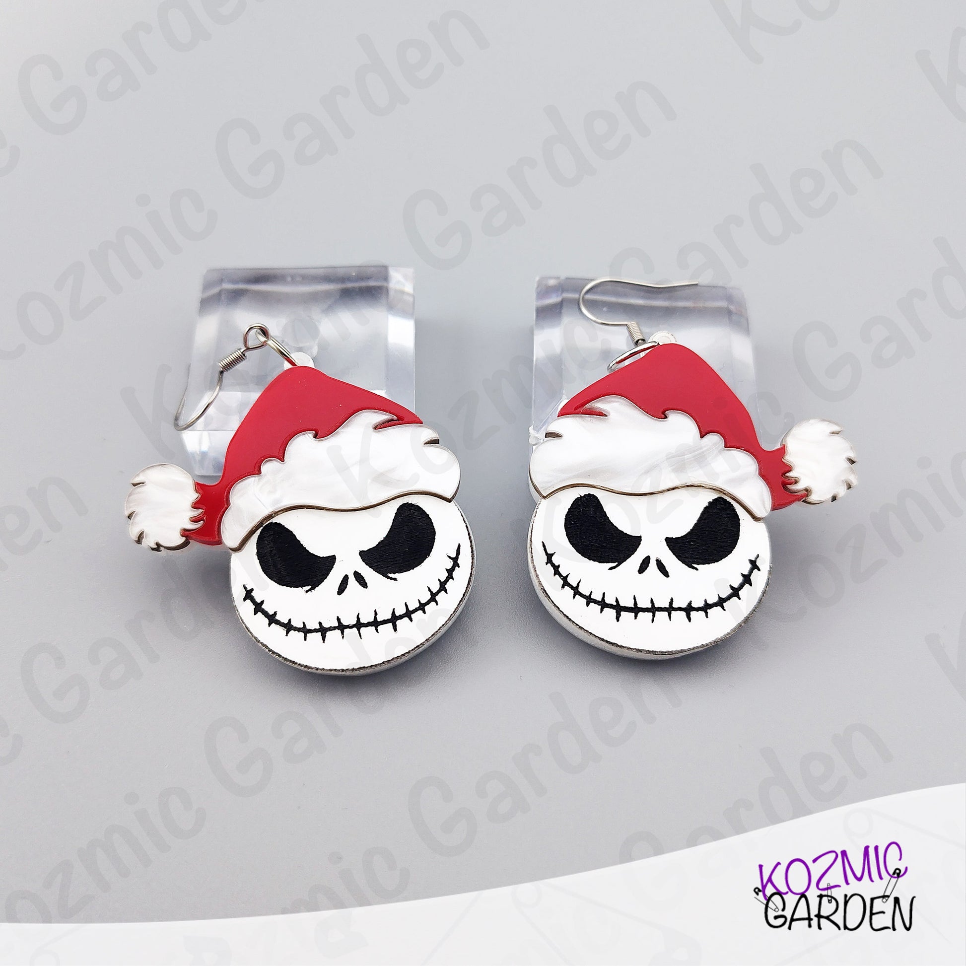 Close look at the black and white Jack Skellington face with a red Santa hat. Lightweight acrylic earrings with crisp engraved details and a glossy finish.