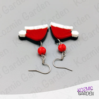 Pair of earrings with red and white design on a gray background with 'Kozmic Garden' branding.